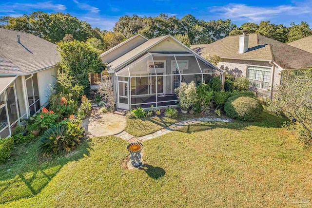 back of property featuring a lanai and a yard