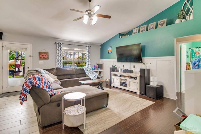 living area with a decorative wall, wood finished floors, a wainscoted wall, a ceiling fan, and vaulted ceiling