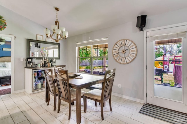 dining space featuring an inviting chandelier, baseboards, and beverage cooler