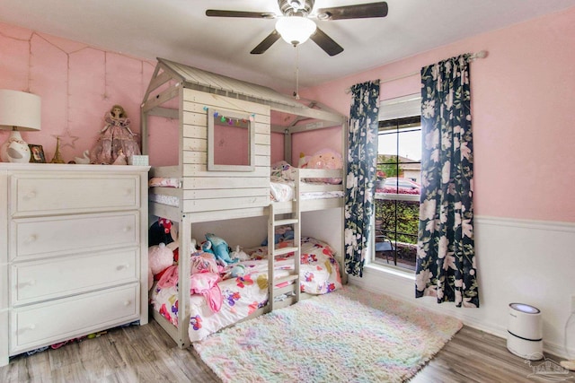 bedroom with a ceiling fan, baseboards, and wood finished floors
