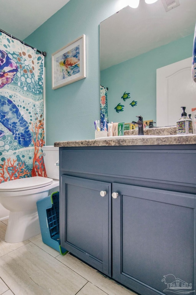 bathroom with vanity, tile patterned floors, and toilet