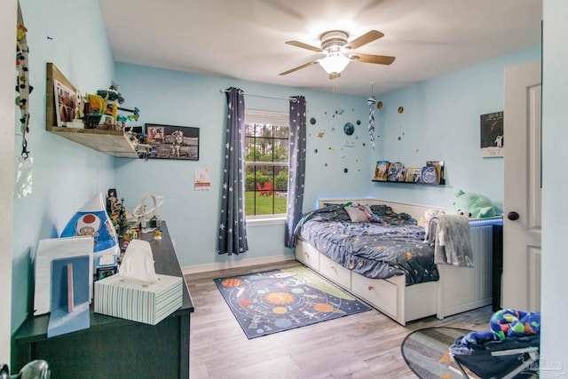 bedroom with baseboards, ceiling fan, and wood finished floors