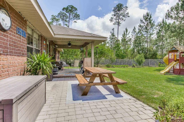 view of patio with outdoor dining space, a ceiling fan, a fenced backyard, and a playground