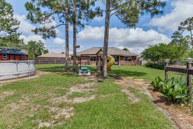 view of yard featuring a playground and fence