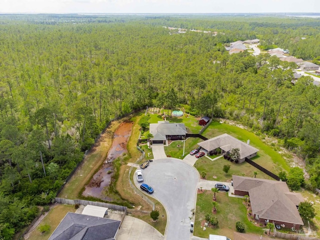 birds eye view of property featuring a wooded view