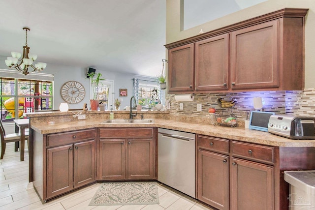 kitchen with a notable chandelier, a sink, dishwasher, a peninsula, and backsplash