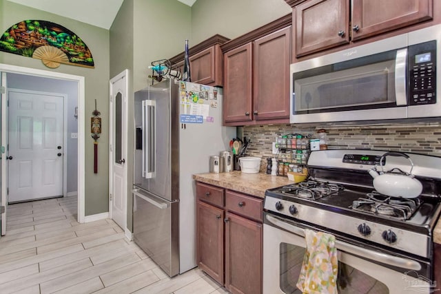 kitchen with light countertops, baseboards, decorative backsplash, and stainless steel appliances