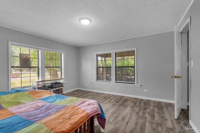 bedroom with wood-type flooring and ornamental molding