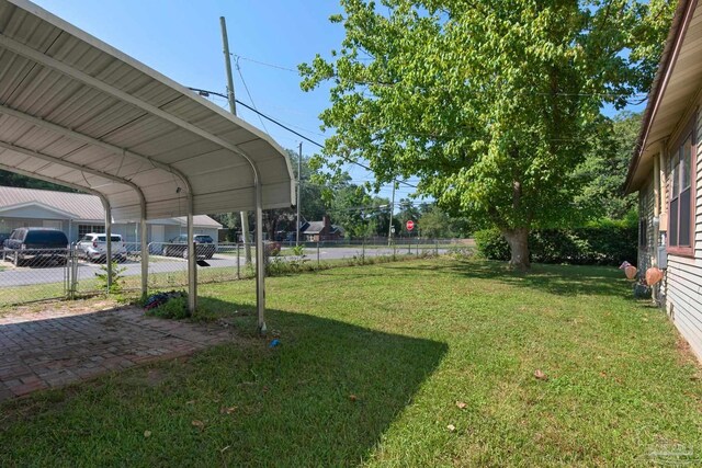 view of car parking with a carport and a yard