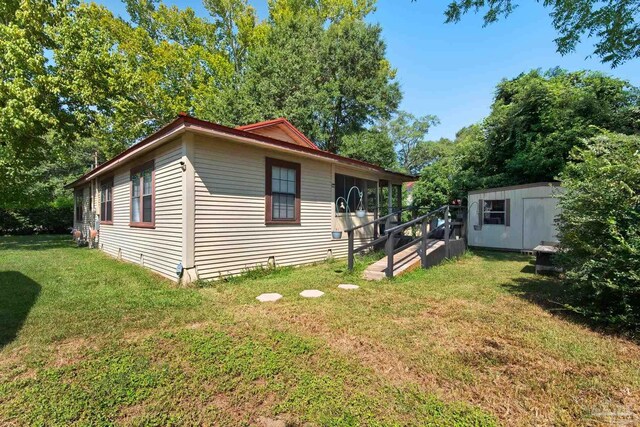 view of property exterior with a storage unit and a yard