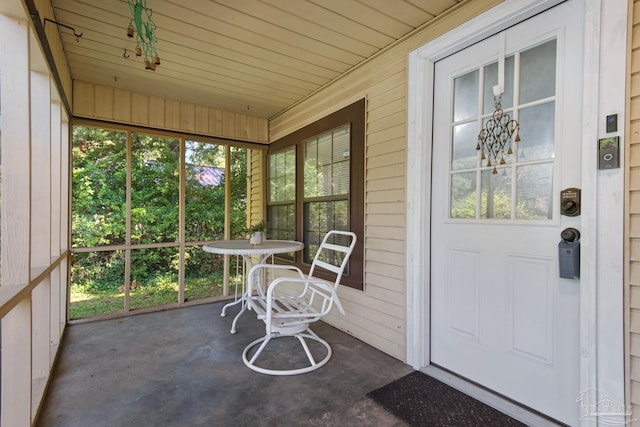 sunroom with an inviting chandelier, a healthy amount of sunlight, and wood ceiling