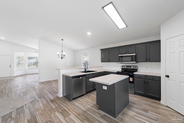 1042 Simpson St, Pensacola, FL 32526 - kitchen featuring stainless steel appliances, lofted ceiling, a sink, light countertops, and a peninsula