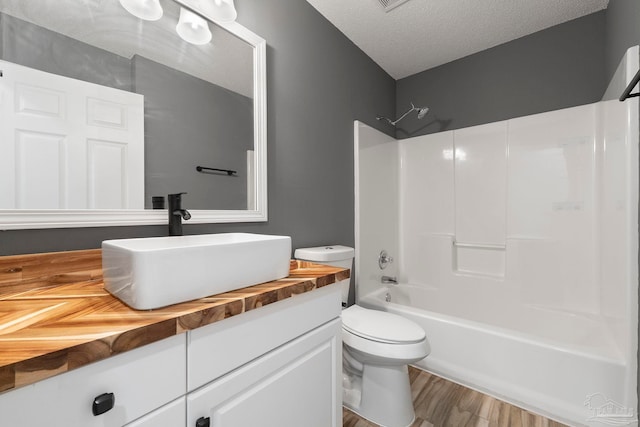 1042 Simpson St, Pensacola, FL 32526 - bathroom featuring vanity, toilet, washtub / shower combination, a textured ceiling, and wood finished floors