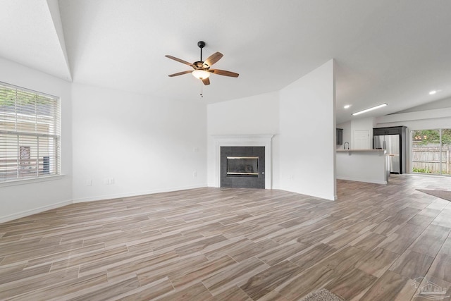 1042 Simpson St, Pensacola, FL 32526 - unfurnished living room with lofted ceiling, a ceiling fan, light wood-style flooring, a tile fireplace, and baseboards