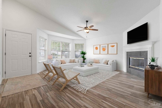 1042 Simpson St, Pensacola, FL 32526 - living area with lofted ceiling, a fireplace, a ceiling fan, light wood-style flooring, and a textured ceiling
