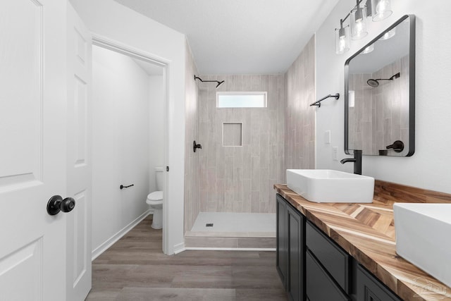 1042 Simpson St, Pensacola, FL 32526 - full bath featuring toilet, vanity, tiled shower, and wood finished floors