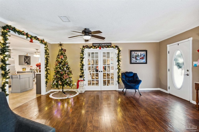 foyer with crown molding, french doors, a textured ceiling, and hardwood / wood-style flooring