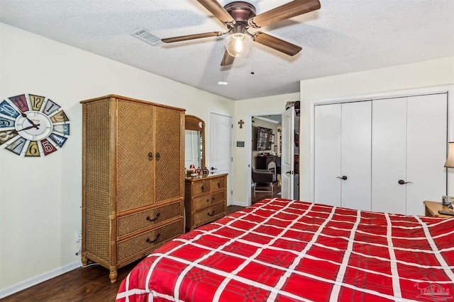 bedroom with a textured ceiling, dark hardwood / wood-style floors, and ceiling fan