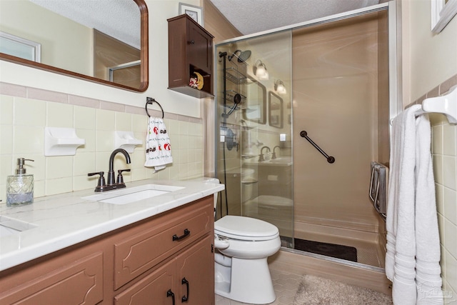 bathroom featuring decorative backsplash, an enclosed shower, vanity, a textured ceiling, and toilet