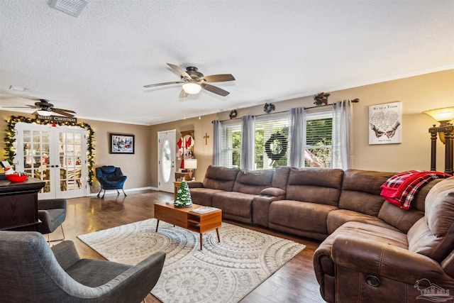 living room with hardwood / wood-style floors, ceiling fan, a textured ceiling, and french doors