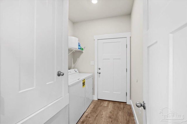 laundry area with washer and clothes dryer and hardwood / wood-style flooring