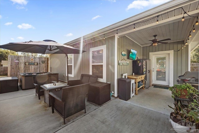 view of patio featuring ceiling fan and a hot tub