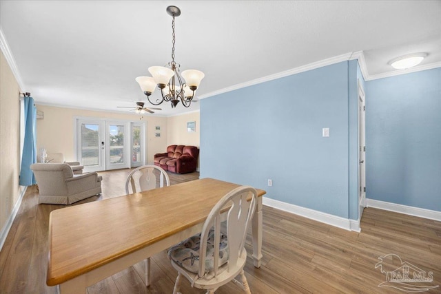 dining room featuring crown molding, french doors, wood-type flooring, and ceiling fan with notable chandelier