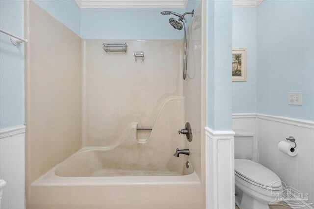 bathroom featuring crown molding, shower / bathing tub combination, and toilet