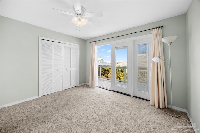 unfurnished bedroom featuring access to exterior, ceiling fan, light colored carpet, and a closet