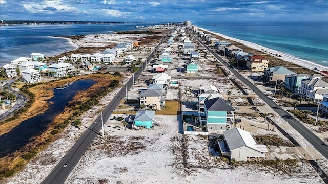 birds eye view of property with a water view and a beach view