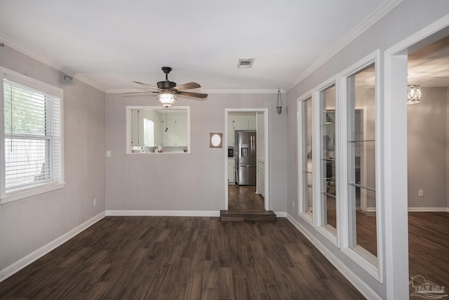 spare room with ornamental molding, dark wood finished floors, visible vents, and baseboards