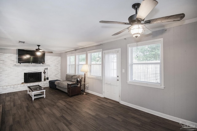 living area with a ceiling fan, ornamental molding, dark wood finished floors, and a wealth of natural light