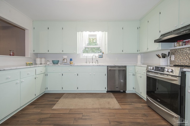 kitchen featuring stainless steel appliances, light countertops, dark wood finished floors, and under cabinet range hood