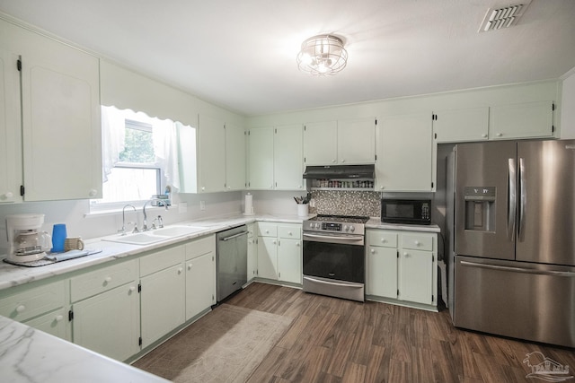 kitchen with dark wood-style floors, visible vents, appliances with stainless steel finishes, a sink, and under cabinet range hood