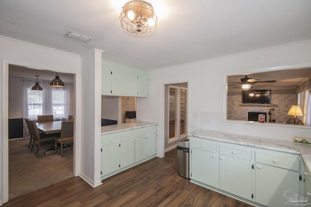 kitchen with dark wood-type flooring, visible vents, and crown molding