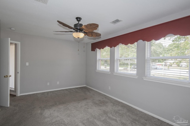 carpeted empty room with a ceiling fan, visible vents, and baseboards