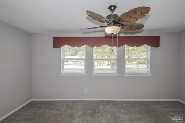 carpeted empty room with a ceiling fan and baseboards