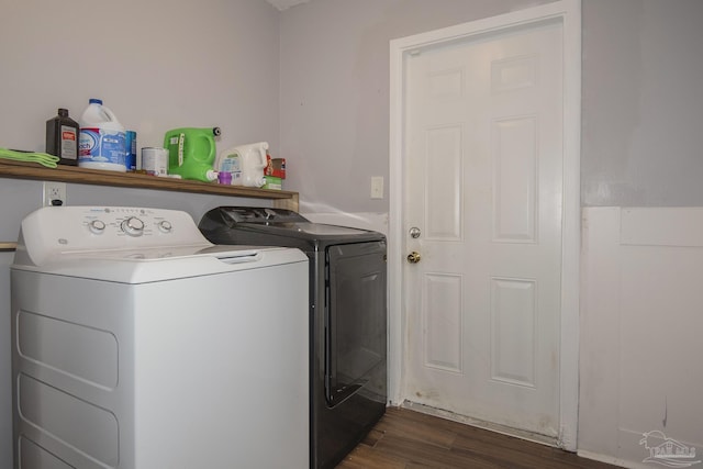 washroom featuring laundry area, washing machine and dryer, and dark wood finished floors