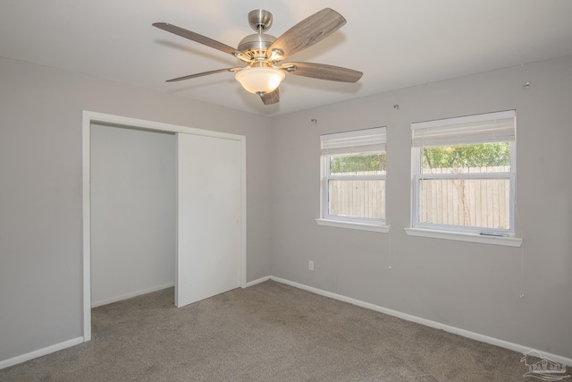 unfurnished bedroom with ceiling fan, carpet floors, a closet, and baseboards