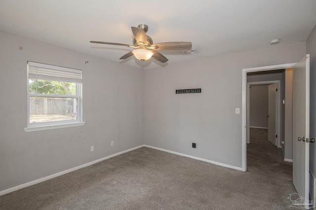 carpeted spare room featuring ceiling fan, visible vents, and baseboards