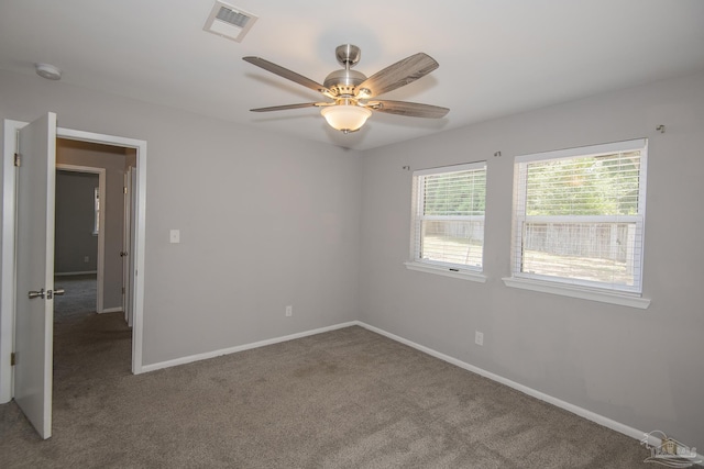 spare room featuring a ceiling fan, carpet, visible vents, and baseboards