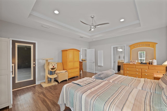 bedroom featuring recessed lighting, a tray ceiling, baseboards, ornamental molding, and dark wood finished floors