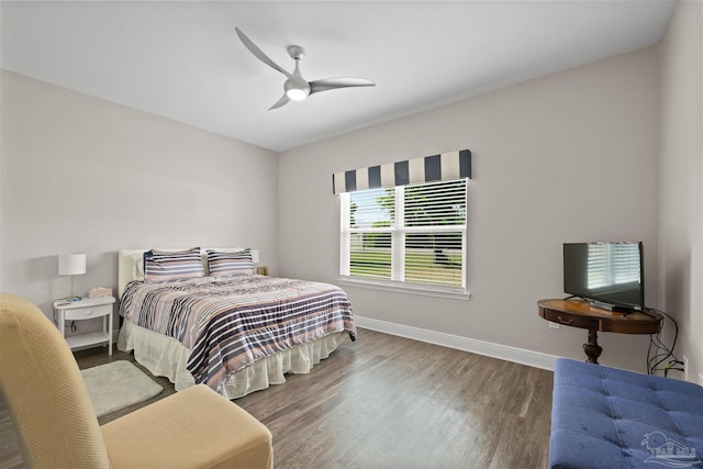 bedroom with ceiling fan, wood finished floors, and baseboards