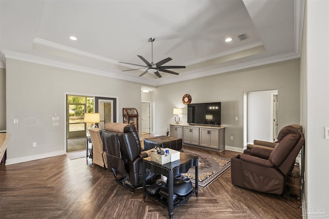 living area featuring ornamental molding, ceiling fan, baseboards, visible vents, and a raised ceiling