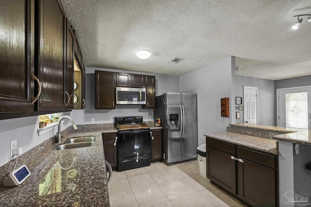 kitchen with visible vents, dark brown cabinetry, a textured ceiling, a sink, and appliances with stainless steel finishes