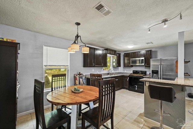 dining area featuring visible vents, a textured ceiling, and light tile patterned floors
