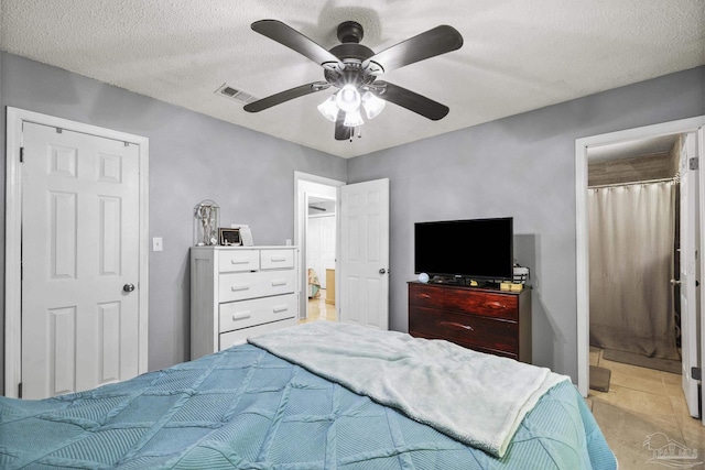bedroom featuring light tile patterned floors, ceiling fan, connected bathroom, and visible vents