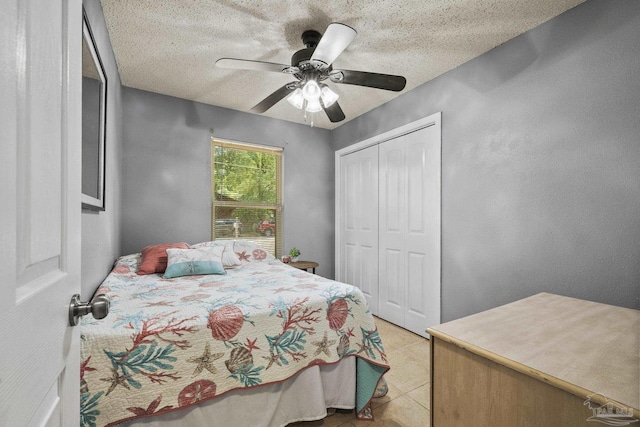 bedroom with light tile patterned flooring, ceiling fan, a textured ceiling, and a closet