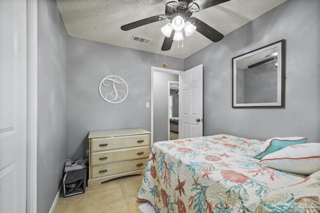 bedroom with visible vents, a ceiling fan, a textured ceiling, and light tile patterned flooring