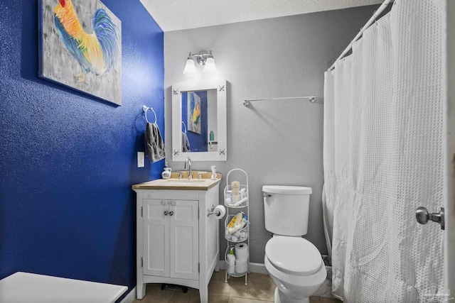 full bath featuring tile patterned flooring, vanity, a textured wall, toilet, and baseboards